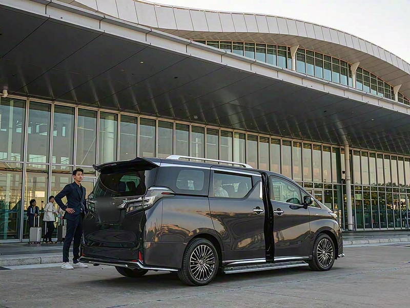 香港国际机场接机大堂外车道上等候中的深色七座商务车与司机